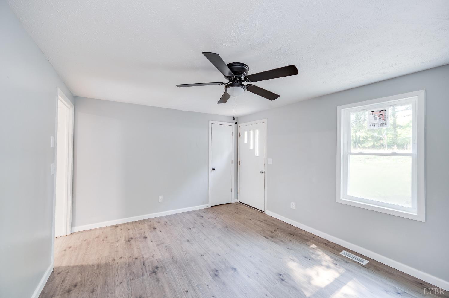 577 Thomas Road Madison Heights, VA 24572 - Photo 3 of 40 a view of empty room with wooden floor and fan