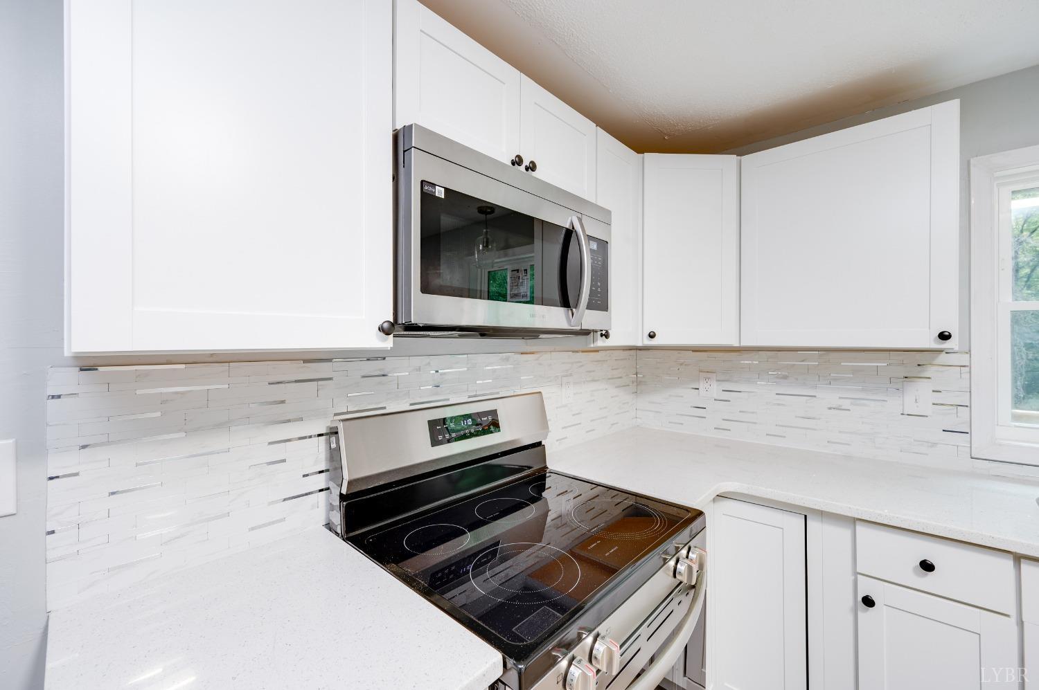 577 Thomas Road Madison Heights, VA 24572 - Photo 6 of 40 a kitchen with granite countertop a stove sink and microwave