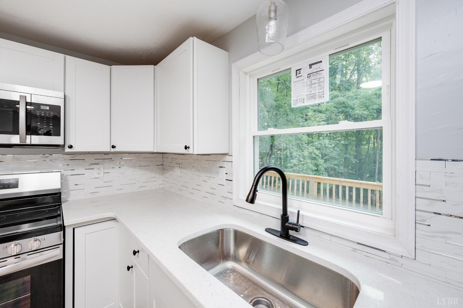 577 Thomas Road Madison Heights, VA 24572 - Photo 9 of 40 a kitchen with a sink cabinets and window