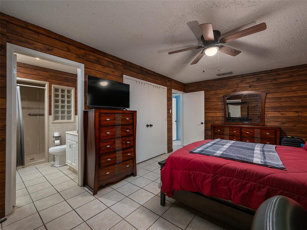 9663 Matise Street Tyler, TX 75706 - Photo 10 of 15 a bedroom with a bed and a flat tv screen