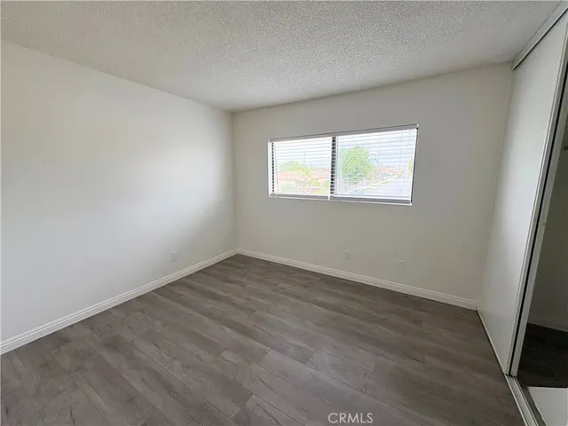 an empty room with wooden floor and window