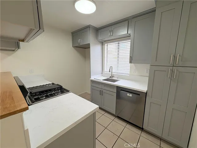 a kitchen with cabinets appliances a sink and a window