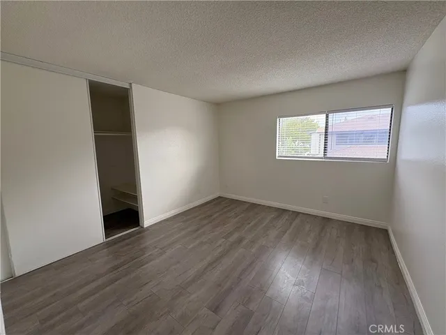 an empty room with wooden floor and window