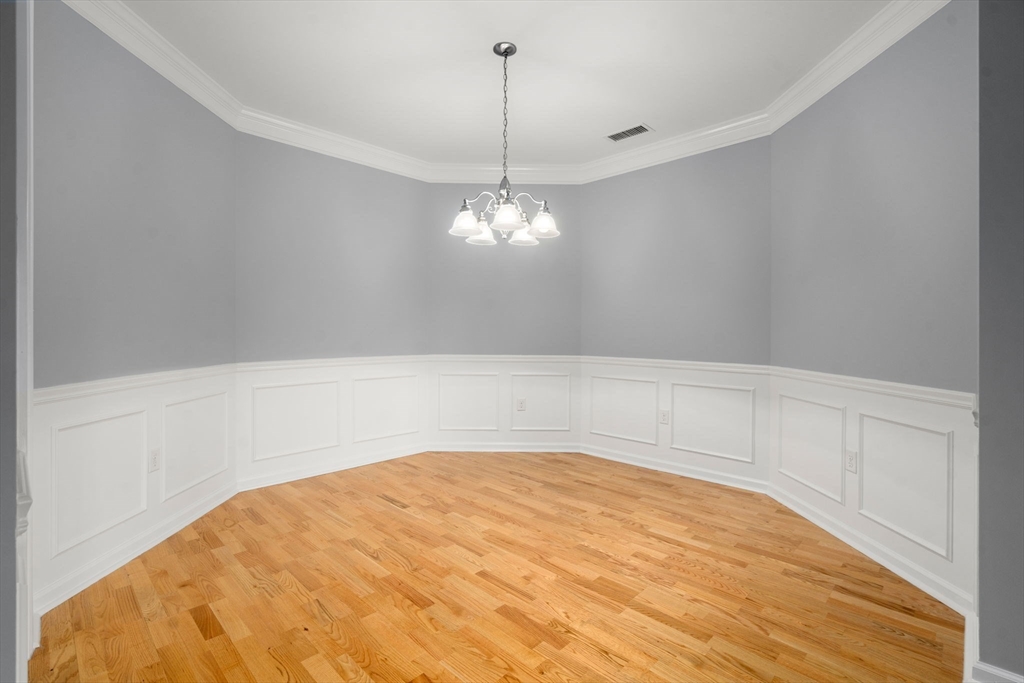 204 Clocktower Drive, Unit 206 Waltham, MA 02452 - Photo 11 of 27 a view of a room with a chandelier fan and wooden floor