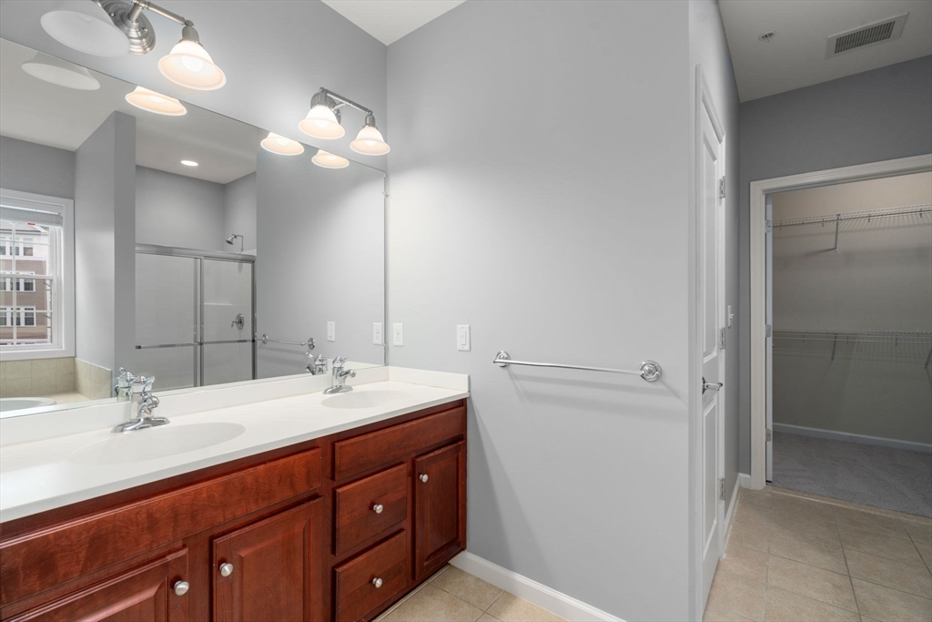 204 Clocktower Drive, Unit 206 Waltham, MA 02452 - Photo 19 of 27 a bathroom with a sink vanity and a mirror