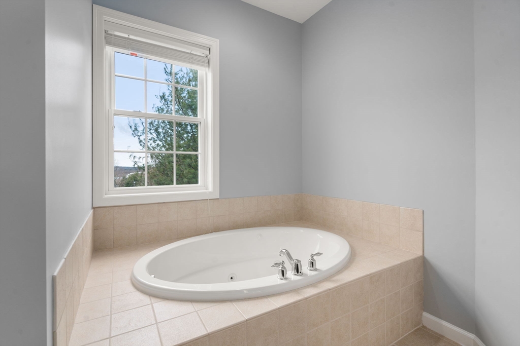 204 Clocktower Drive, Unit 206 Waltham, MA 02452 - Photo 20 of 27 a white bath tub sitting in a bathroom next to a window