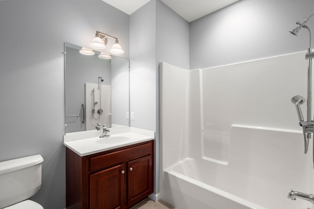 204 Clocktower Drive, Unit 206 Waltham, MA 02452 - Photo 22 of 27 a bathroom with a bathtub shower sink vanity and toilet