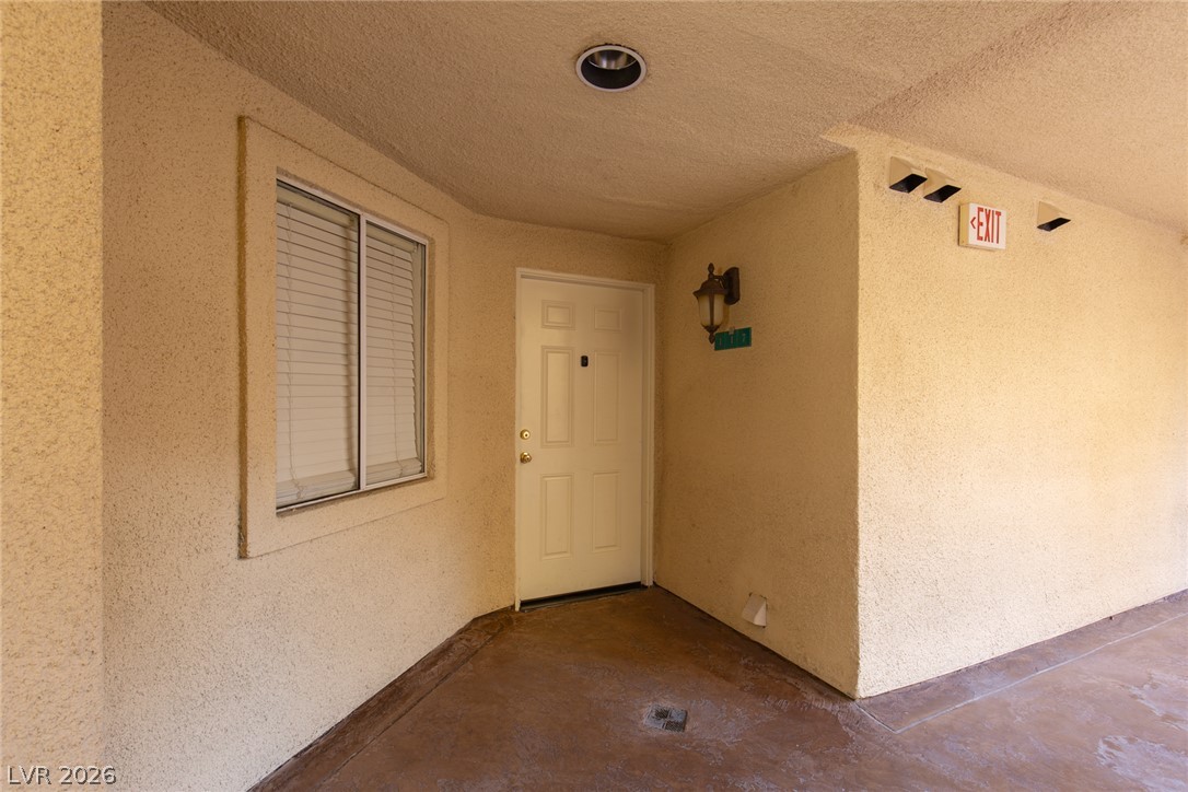 210 East Flamingo Road, Unit 117 Las Vegas, NV 89169 - Photo 6 of 24 A sheltered entrance pathway leads to a private unit entry with smooth concrete flooring.