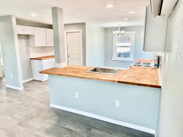 a kitchen with stainless steel appliances granite countertop a sink a stove and a refrigerator