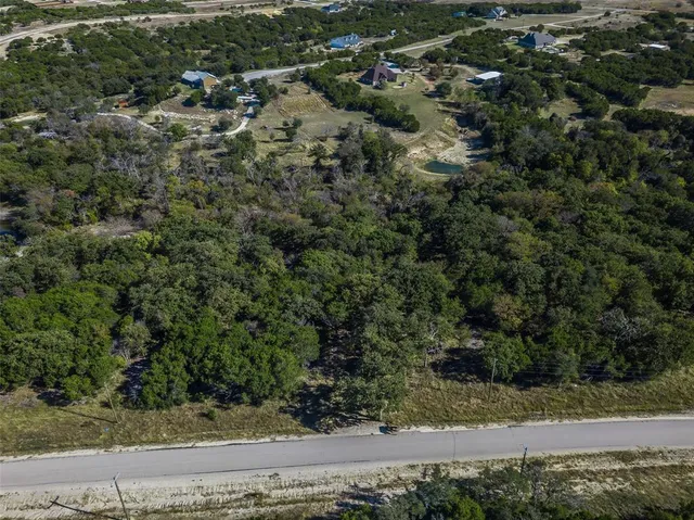 an aerial view of residential house with trees all around
