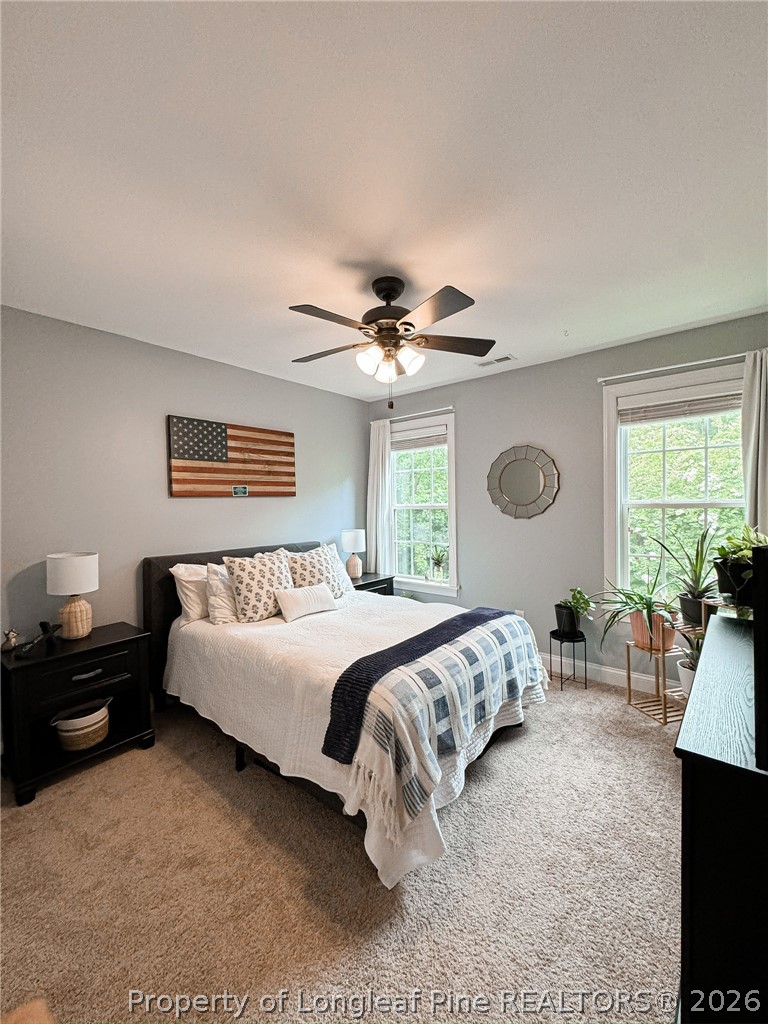 93 Falcon Ridge Drive Spring Lake, NC 28390 - Photo 29 of 50 a spacious bedroom with a bed and a chandelier