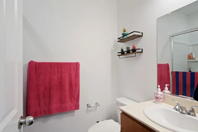 a bathroom with a sink vanity mirror and toilet