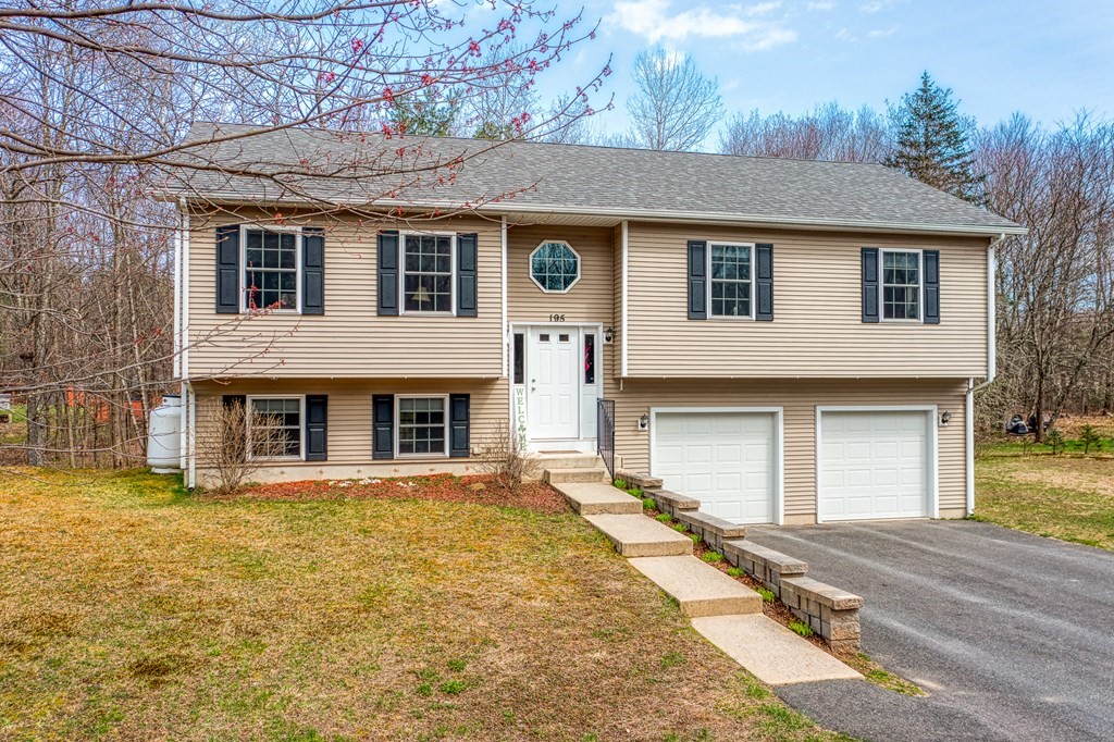 195 Brickyard Road Southampton, MA 01073 - Photo 2 of 42 a front view of a house with a yard and garage