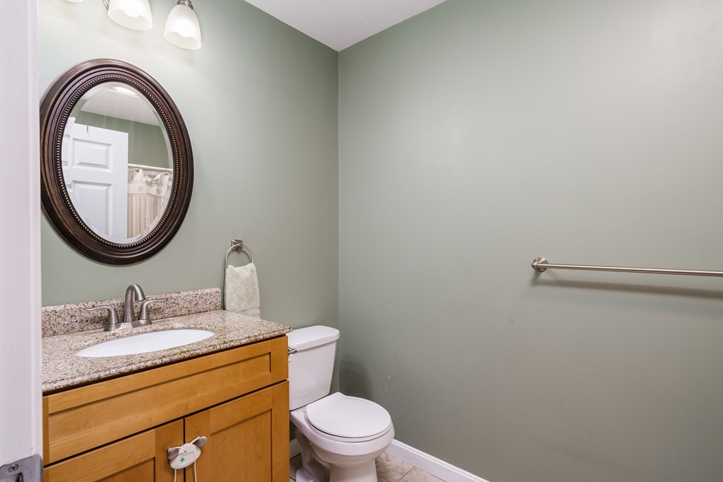 195 Brickyard Road Southampton, MA 01073 - Photo 30 of 42 a bathroom with a granite countertop toilet a sink and a mirror