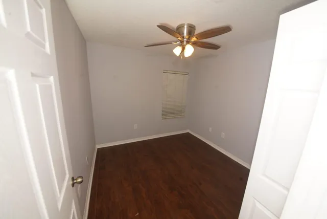 a view of a hallway with a chandelier fan