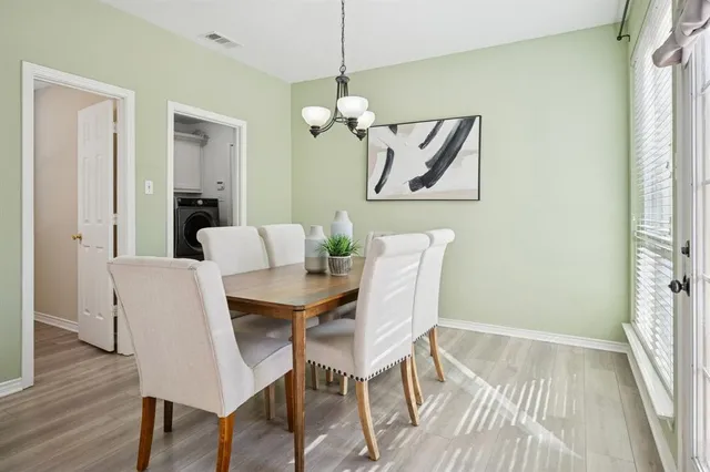 a dining room with wooden floor a glass table and chairs