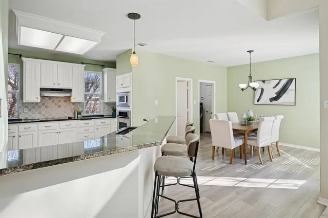 a view of kitchen and dining area with a chandelier