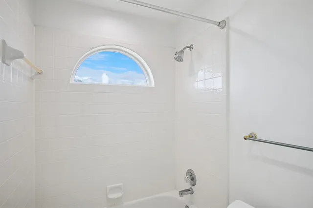 a bathroom with a window and a shower
