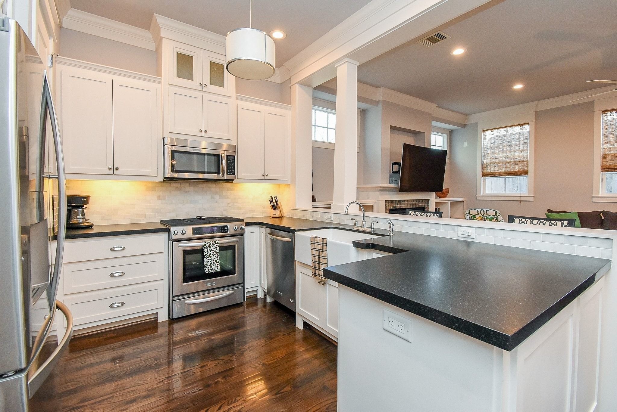 1036 Kern Street Houston, TX 77009 - Photo 15 of 47 The range offers a 5-burner gas cooktop with gas oven underneath, and built-in microwave above. The white porcelain apron-front sink is deep and wide. Fabulously connected to the main Living Room. Again ... the architectural details here are anything but cookie cutter!