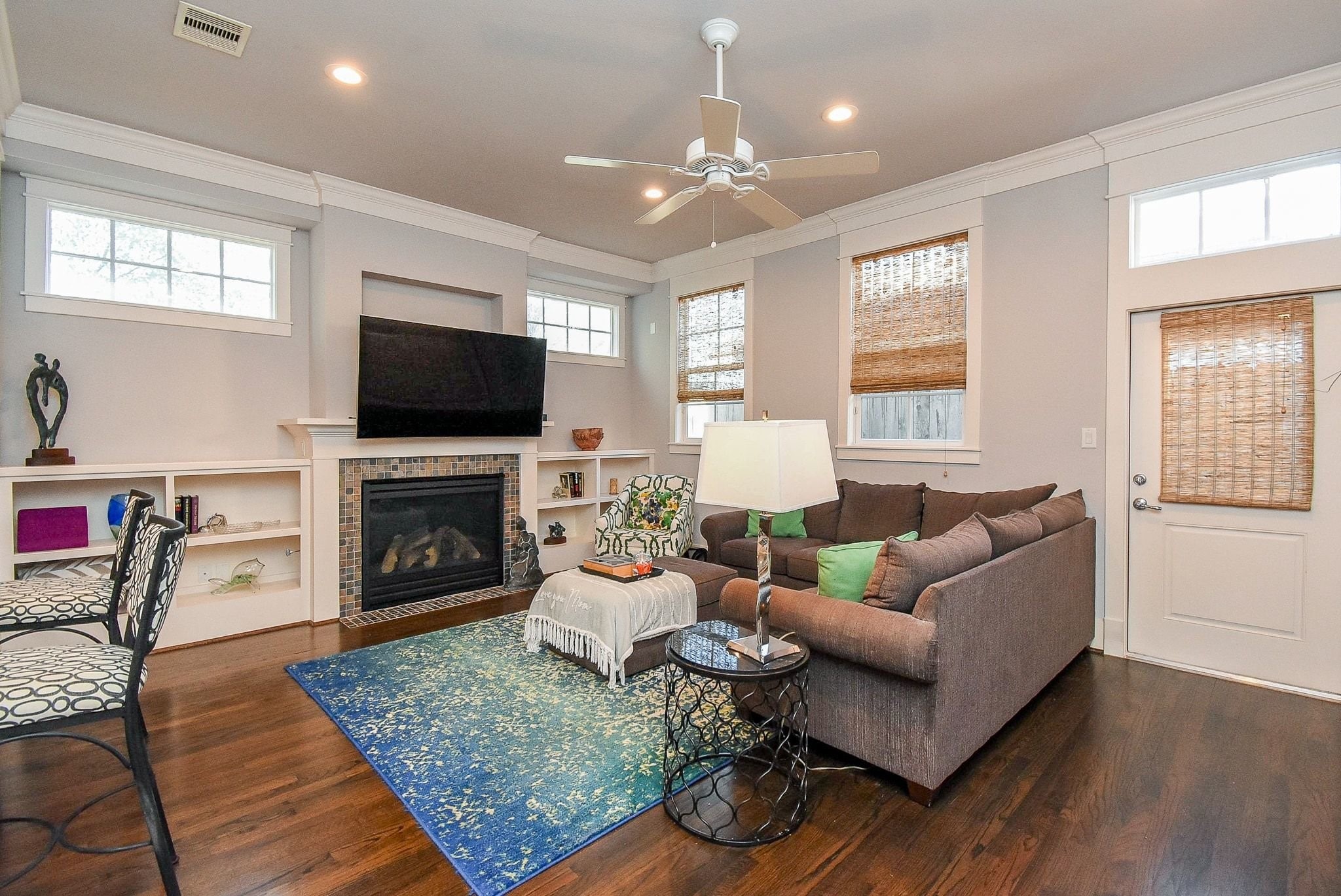 1036 Kern Street Houston, TX 77009 - Photo 21 of 47 This room is spacious and yet still manages to achieve cozy at the same time! It has fabulous built-in open shelves on both sides of the tiled gas fireplace. The perfect spot for displaying your collectibles & cherished possessions. Wood woven shades adorn the windows and door which exits to a small, graveled backyard.