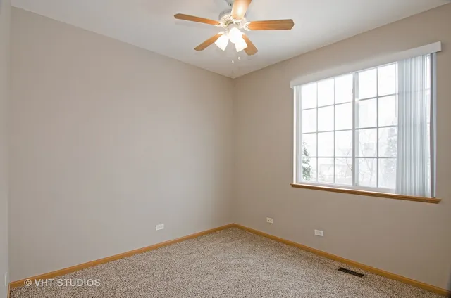 an empty room with a window and a fan