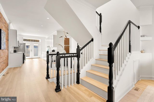a view of a hallway with wooden floor and staircase
