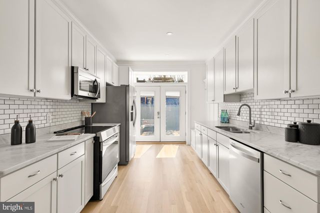 a kitchen with stainless steel appliances granite countertop a sink stove and cabinets