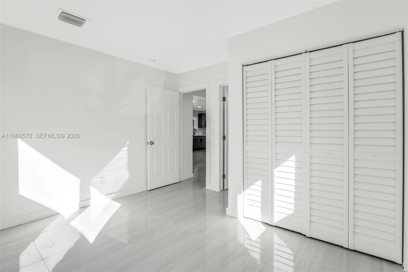 528 Northwest 3rd Court Hallandale Beach, FL 33009 - Photo 13 of 25 a view of empty room with wooden floor and fan