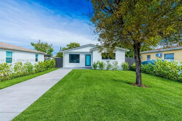 a front view of a house with a yard and green space
