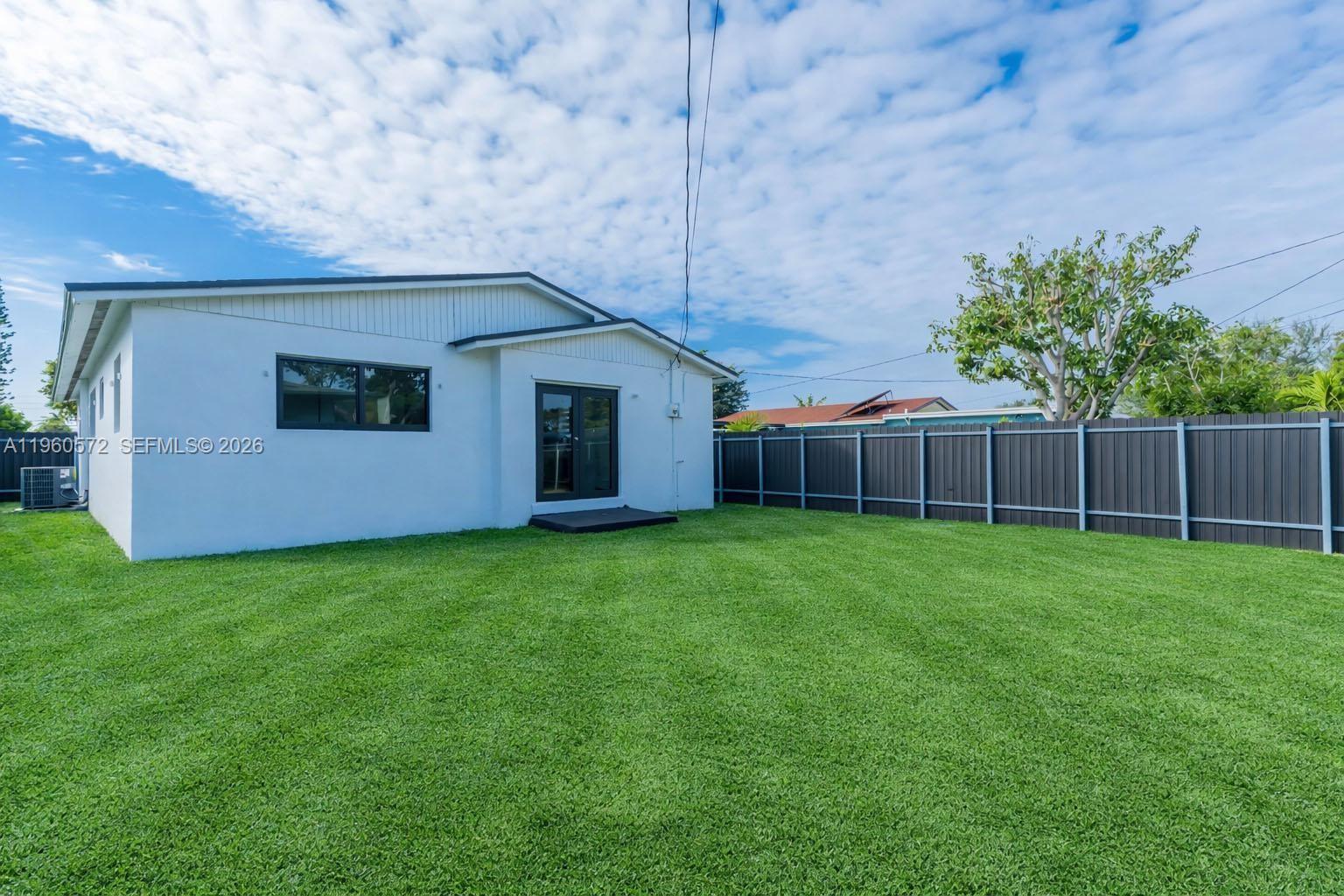 528 Northwest 3rd Court Hallandale Beach, FL 33009 - Photo 23 of 25 a view of backyard with potted plants and wooden fence