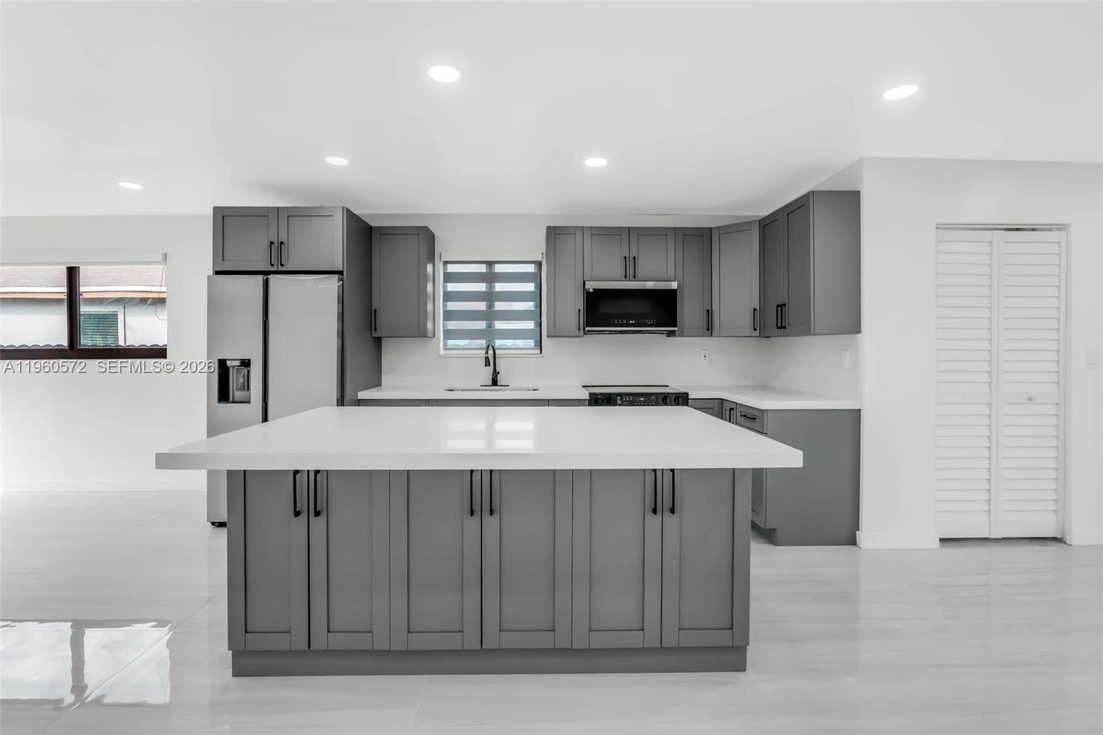 528 Northwest 3rd Court Hallandale Beach, FL 33009 - Photo 5 of 25 a kitchen with kitchen island a sink stainless steel appliances and cabinets