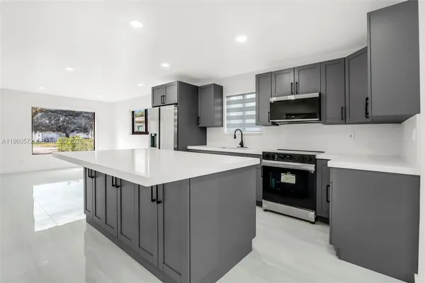 a kitchen with stainless steel appliances a stove sink microwave and cabinets