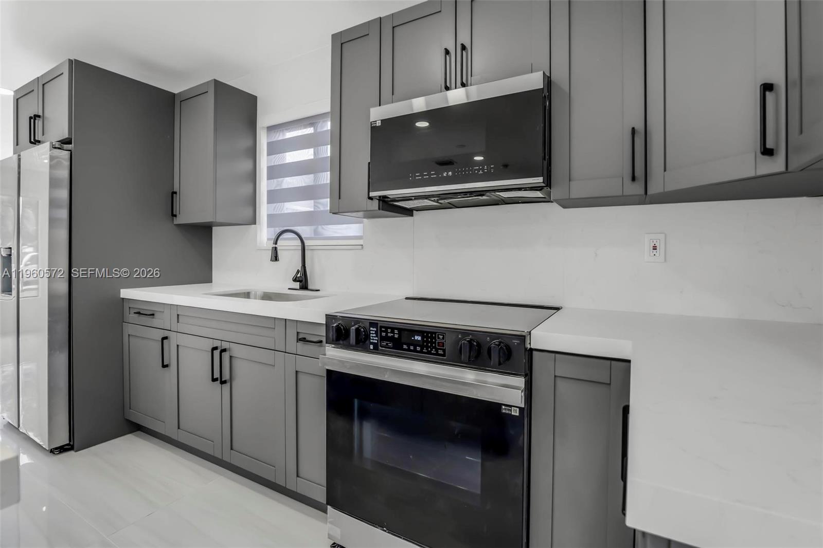 528 Northwest 3rd Court Hallandale Beach, FL 33009 - Photo 7 of 25 a kitchen with stainless steel appliances a stove microwave and sink