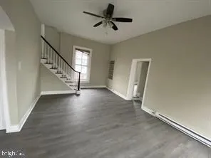 a view of a livingroom with wooden floor and a ceiling fan