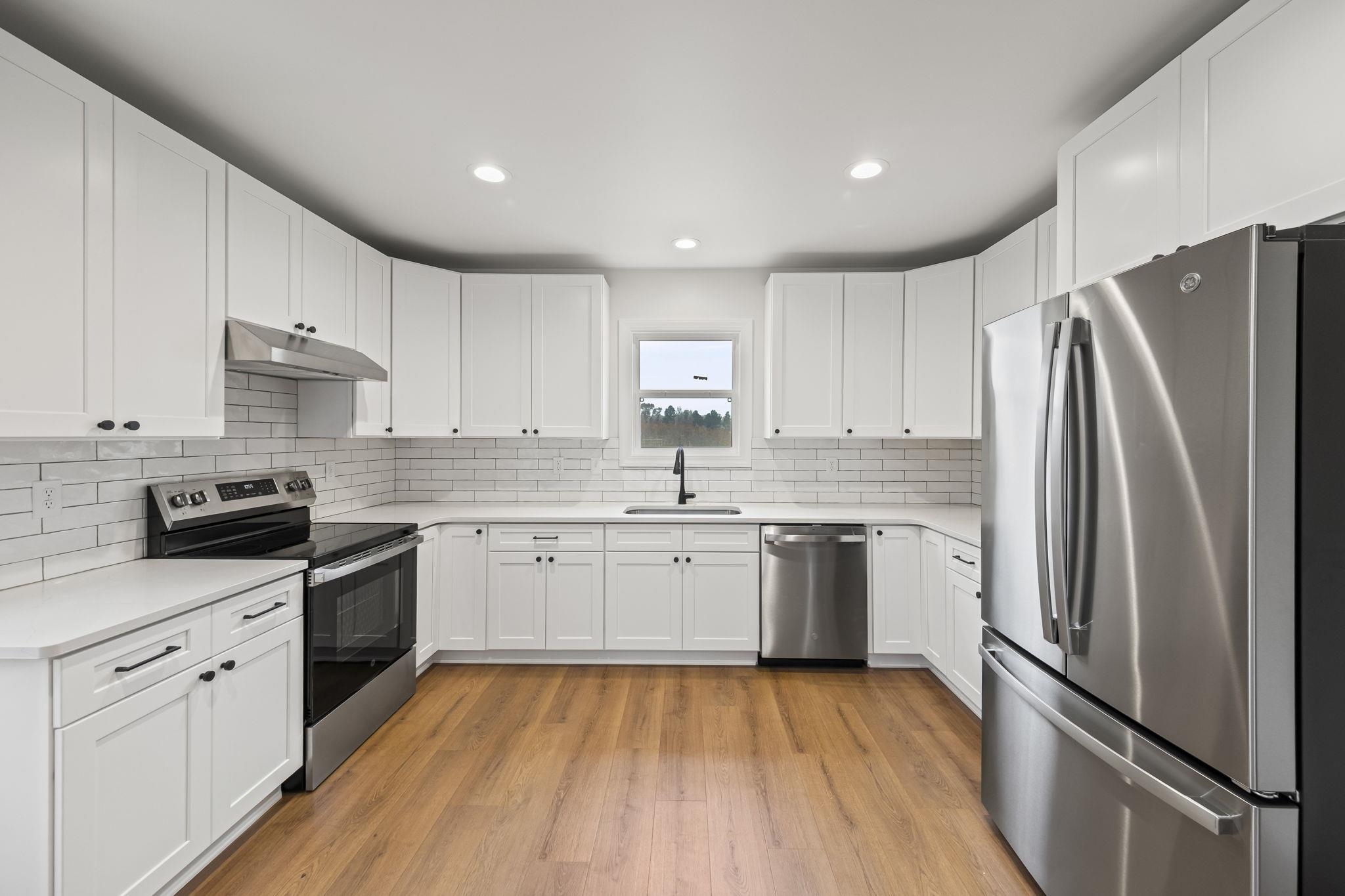 835 Curve Woodville Road Gates, TN 38037 - Photo 7 of 30 Kitchen featuring appliances with stainless steel finishes, white cabinets, recessed lighting, under cabinet range hood, and light wood finished floors