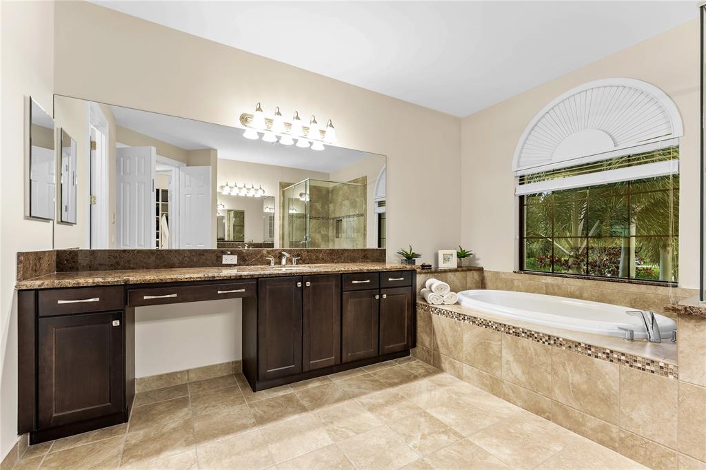 9571 Eden Roc Court Delray Beach, FL 33446 - Photo 25 of 45 a spacious bathroom with a granite countertop bathtub a sink and a large mirror
