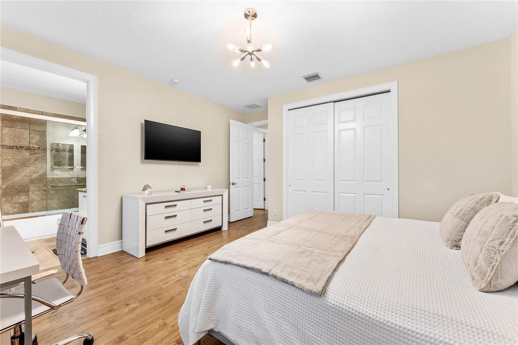 9571 Eden Roc Court Delray Beach, FL 33446 - Photo 29 of 45 a bedroom with a bed and a flat screen tv