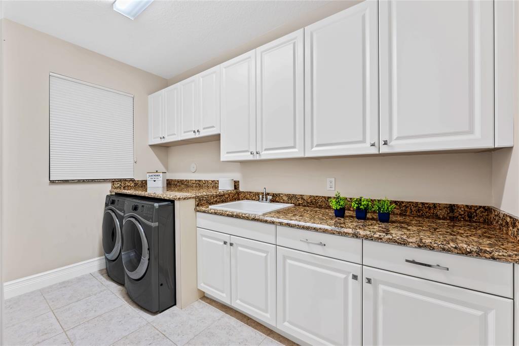 9571 Eden Roc Court Delray Beach, FL 33446 - Photo 31 of 45 a utility room with cabinets