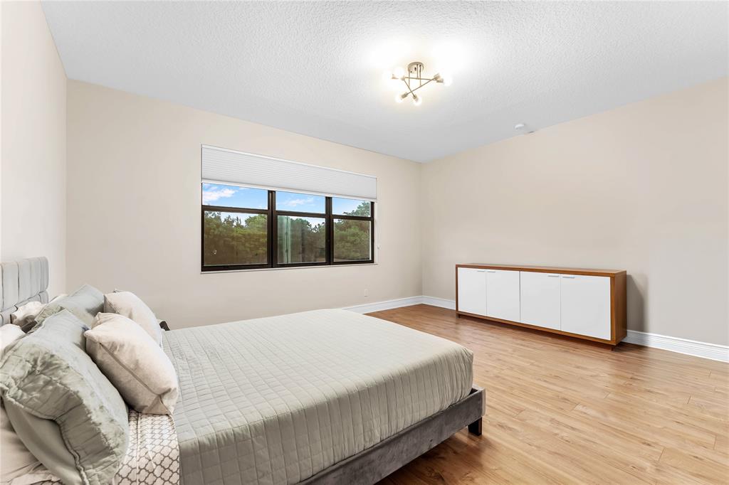 9571 Eden Roc Court Delray Beach, FL 33446 - Photo 33 of 45 a bedroom with a large bed and a window