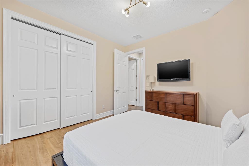 9571 Eden Roc Court Delray Beach, FL 33446 - Photo 34 of 45 a bedroom with a bed and a flat screen tv