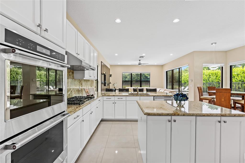 9571 Eden Roc Court Delray Beach, FL 33446 - Photo 8 of 45 a large white kitchen with granite countertop a large window and stainless steel appliances