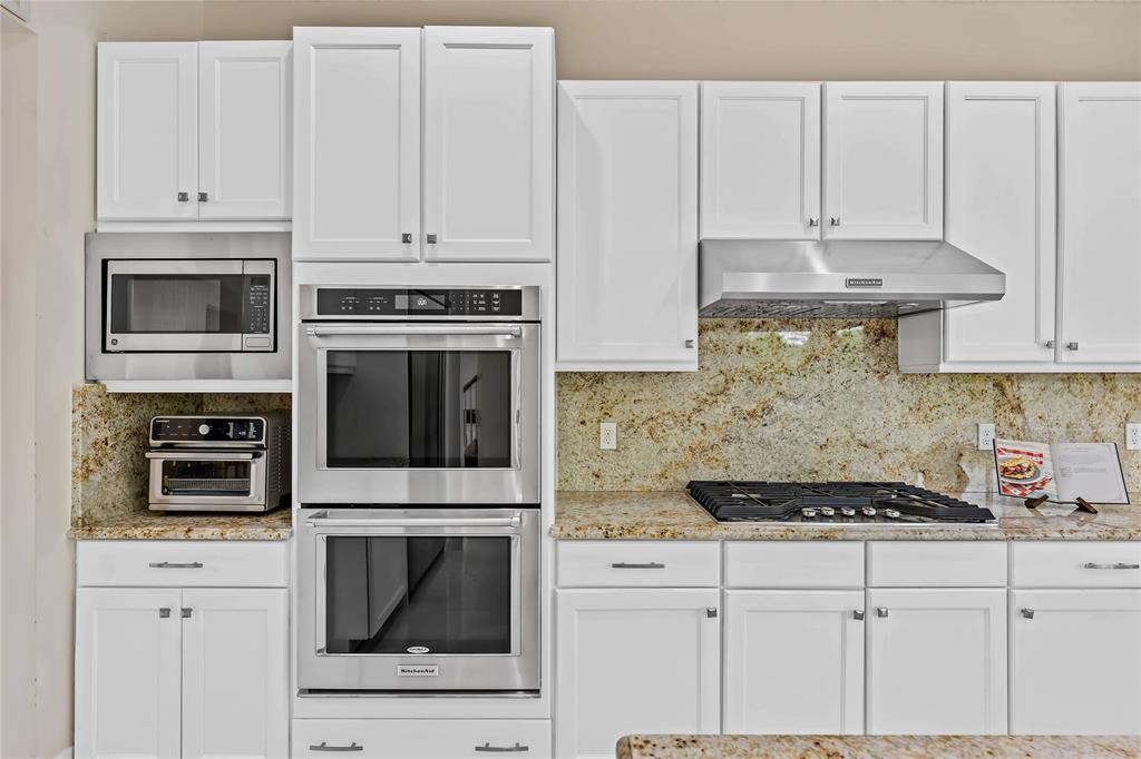 9571 Eden Roc Court Delray Beach, FL 33446 - Photo 9 of 45 a kitchen with granite countertop white cabinets and stainless steel appliances