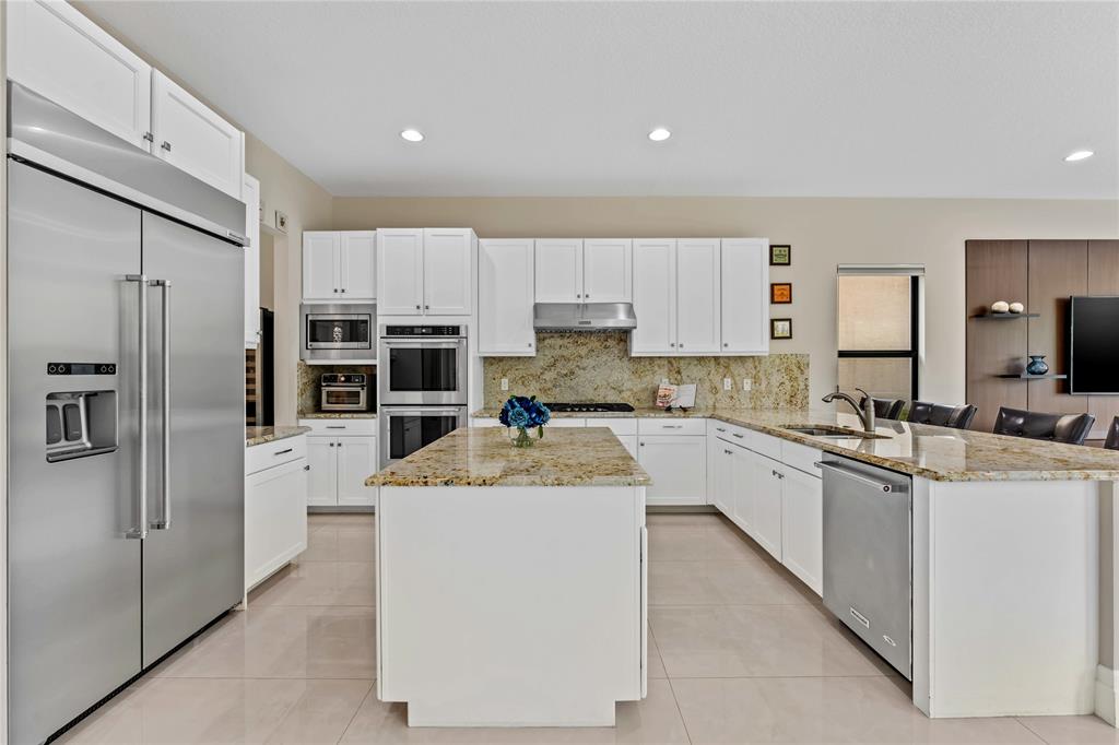 9571 Eden Roc Court Delray Beach, FL 33446 - Photo 10 of 45 a large kitchen with cabinets stainless steel appliances and a counter space