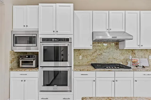 a open kitchen with cabinets stainless steel appliances and a window