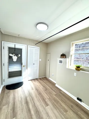 a view of a room with wooden floor and a window