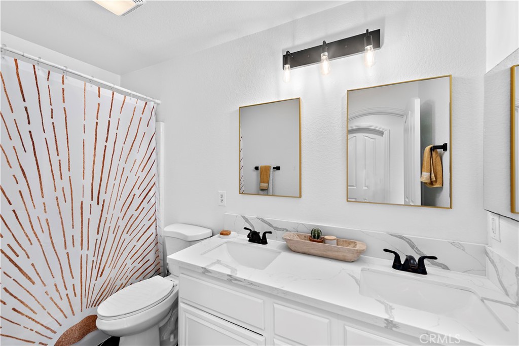 4314 Silver Spring Way Oceanside, CA 92057 - Photo 23 of 49 a bathroom with a sink a toilet and mirror