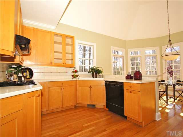 5256 Mill Dam Road Wake Forest, NC 27587 - Photo 11 of 25 ~Washing dishes would almost be enjoyable in this kitchen! Natural wood cabinetry, tile backsplash, solid surface countertops are just some of the many features. The kitchen pantry has custom built-in wooden shelving.~