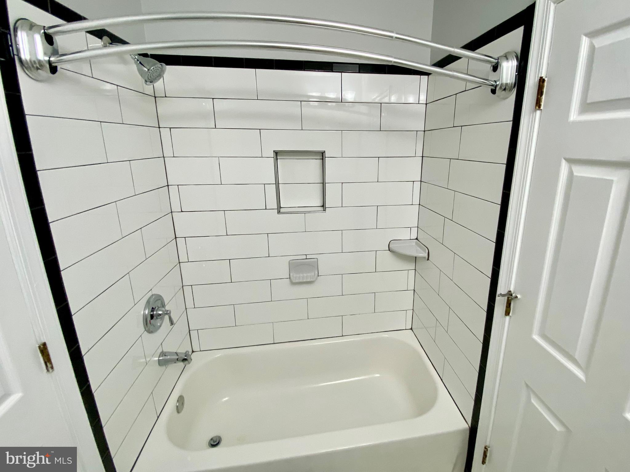 4733 Bradley Boulevard, Unit 11 Chevy Chase, MD 20815 - Photo 6 of 10 a bathroom with a shower and a bath tub