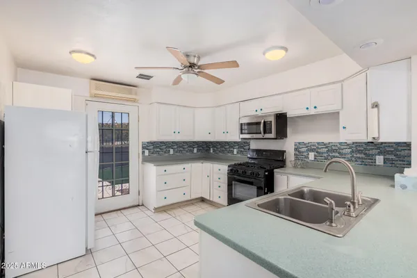 a kitchen with granite countertop white cabinets white stainless steel appliances with a sink and dishwasher