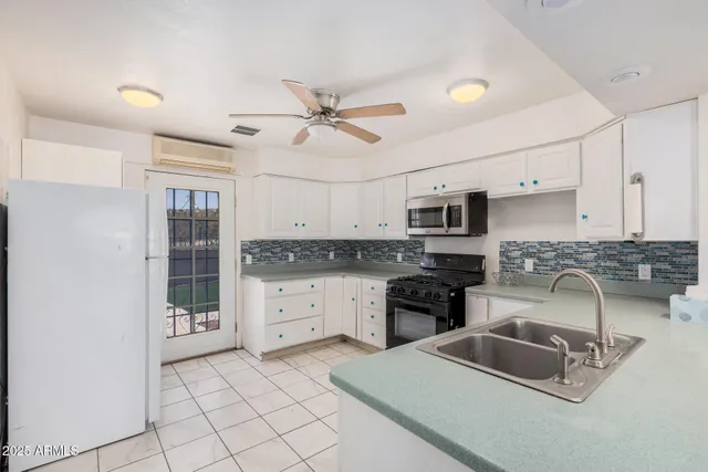 a kitchen with granite countertop white cabinets white stainless steel appliances with a sink and dishwasher